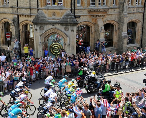 The 2014 Tour de France riding past the Chronophage clock at Corpus Christi College Cambridge