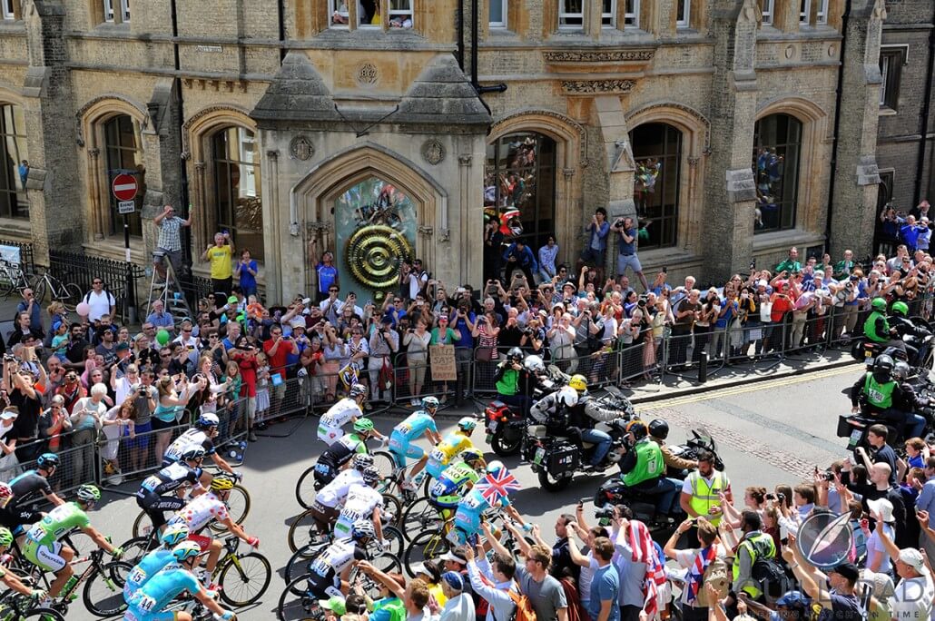 The 2014 Tour de France riding past the Chronophage clock at Corpus Christi College Cambridge