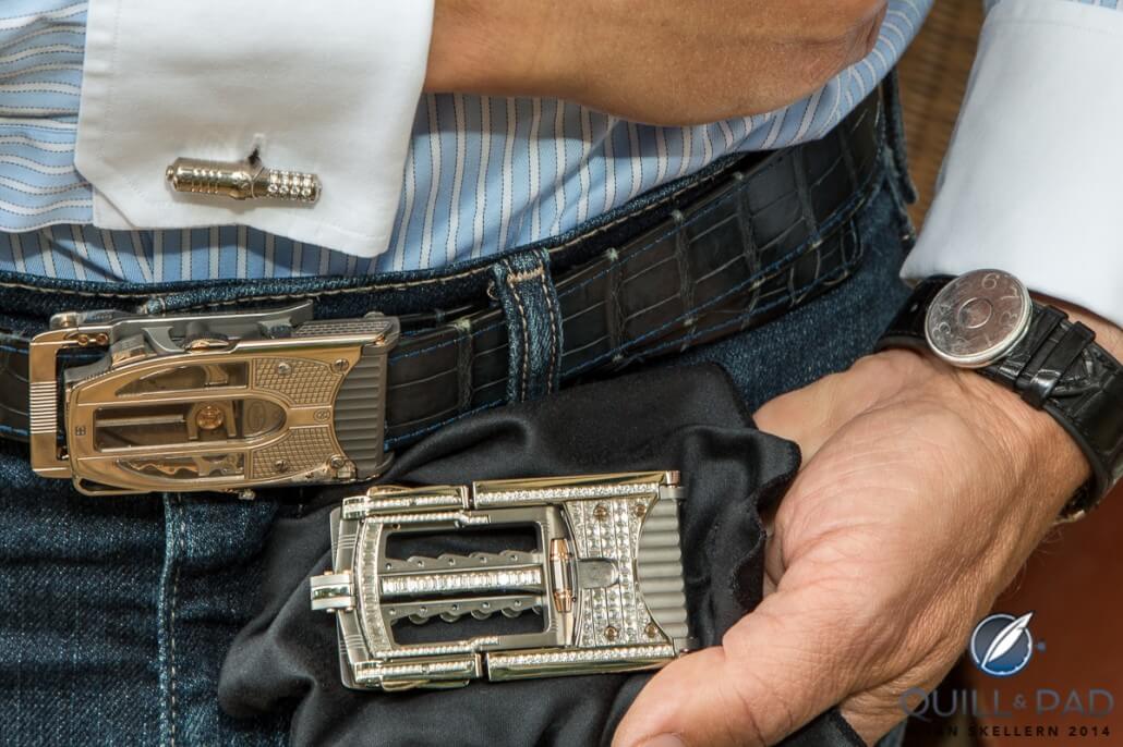 Roland Iten wearing his mechanical cufflinks and a Bugatti belt buckle while holding a full-pavé Caliber R822 Predator buckle; note the circular, adjustable clasp on the watch strap that Iten developed for F.P. Journe