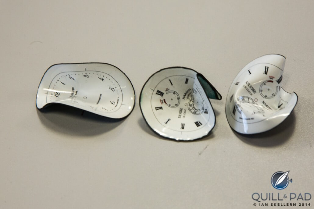 When heated to the right temperature, enamel dials can be bent without cracking the enamel, but ascertaining the correct temperature is not so easy (these are crushed rejects)