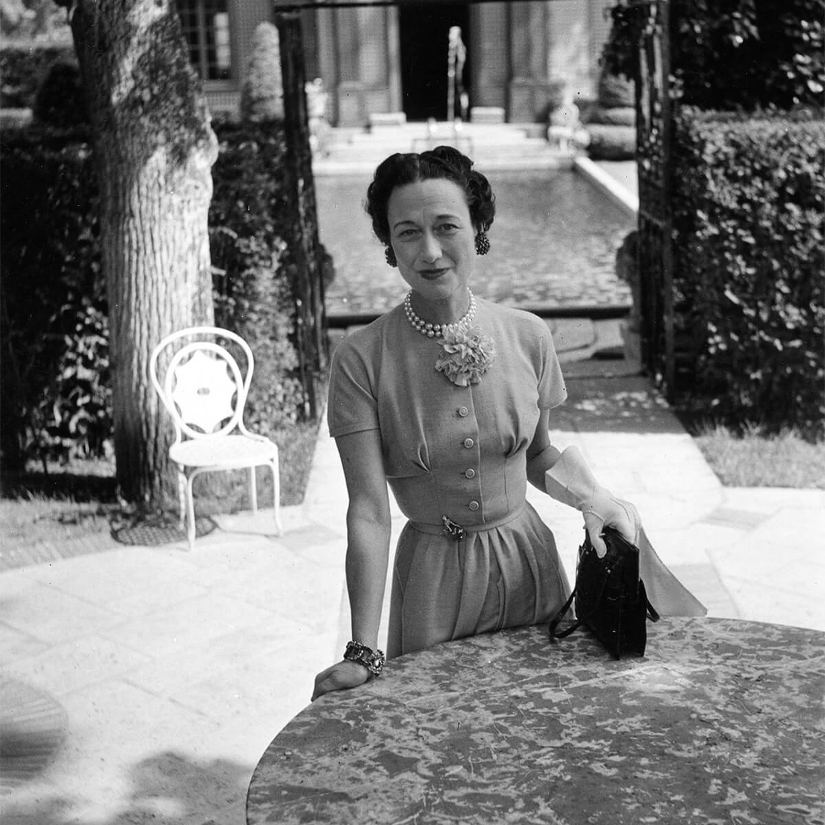 The Duchess of Windsor (Wallis Simpson) in 1949 at Villa Trianon in Versailles; note the panther brooch boasting the 152-carat sapphire cabochon pinned to the belt of her dress