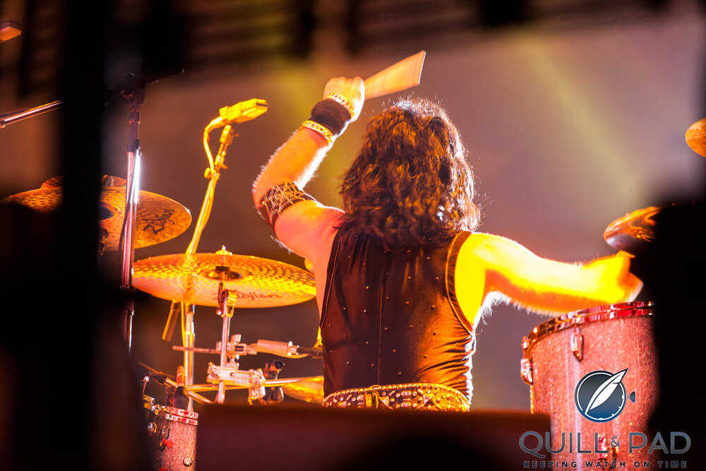 Eric Singer drumming with Kiss in concert; note the wristwatch under the sweatband on his left arm