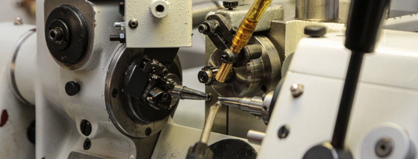 The business end of an automatic lathe at the Nomos manufacture in which the component being turned spins while the cutting tool is stable