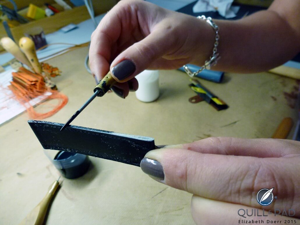Applying black dye to the sides of the Hermés leather strap to make the color uniform