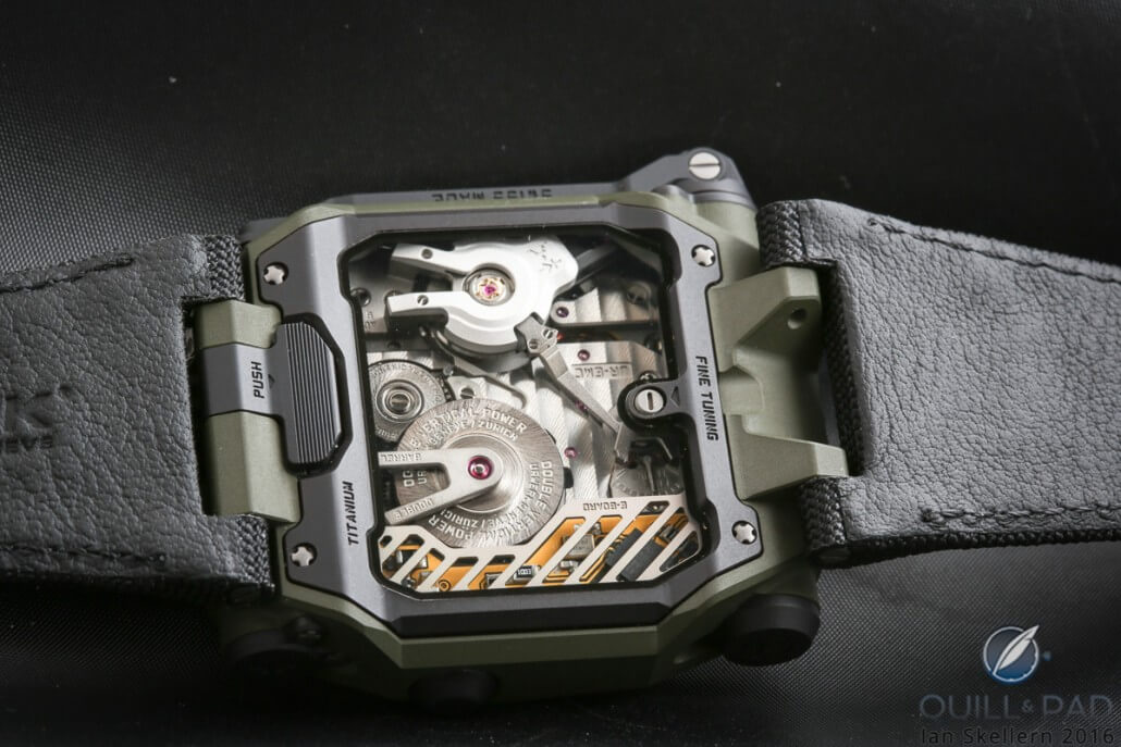 View of the back of the Urwerk EMC2 with the crown pusher on the left, precision fine tuning screw on the right, white balance cover with optical sensor at the top, and micro processor at the bottom