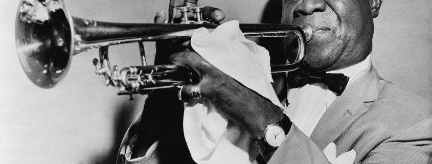Louis Armstrong playing trumpet in 1953, wearing his prized gold wristwatch