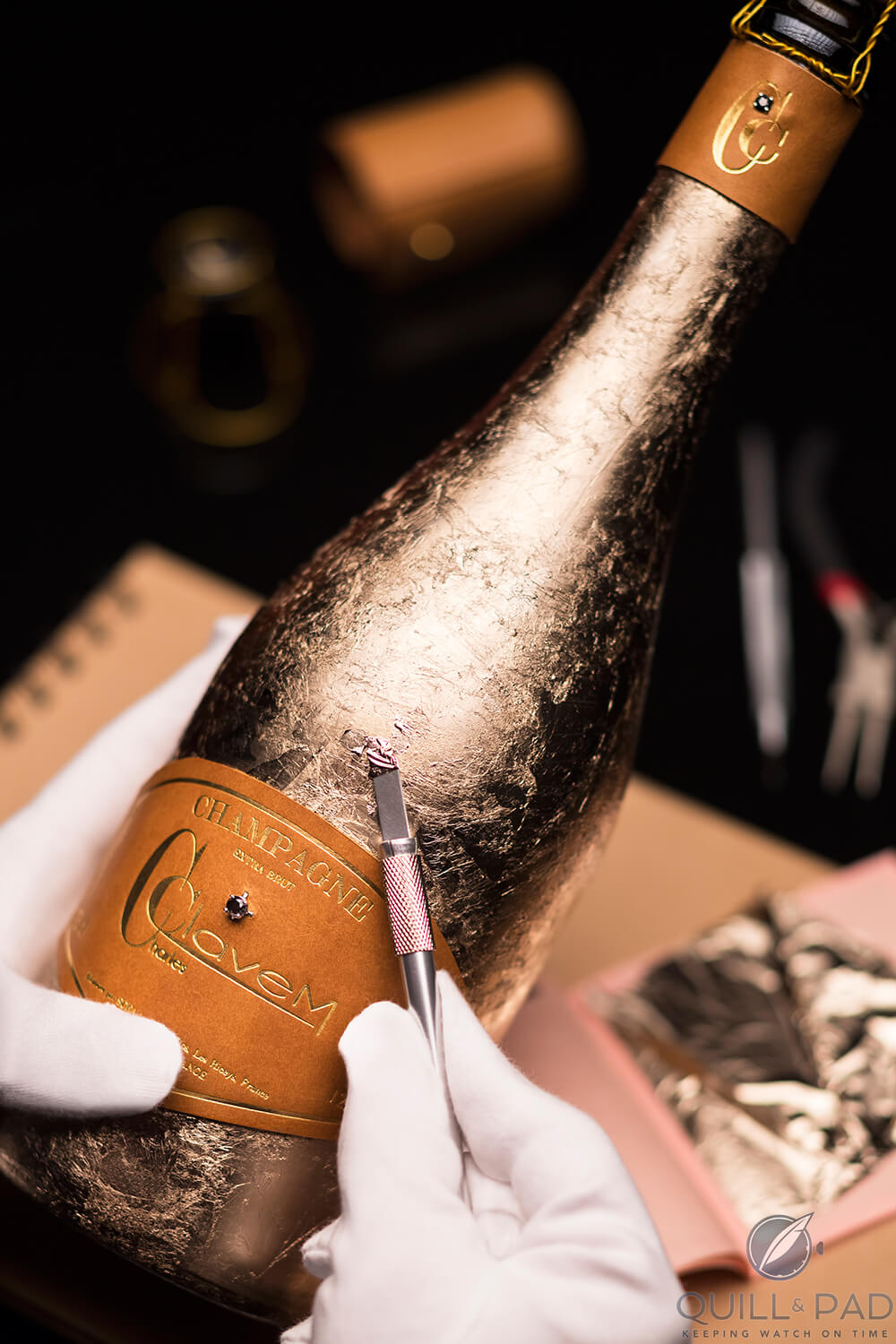 Applying textured gold foil to a bottle of Charles Clavem champagne